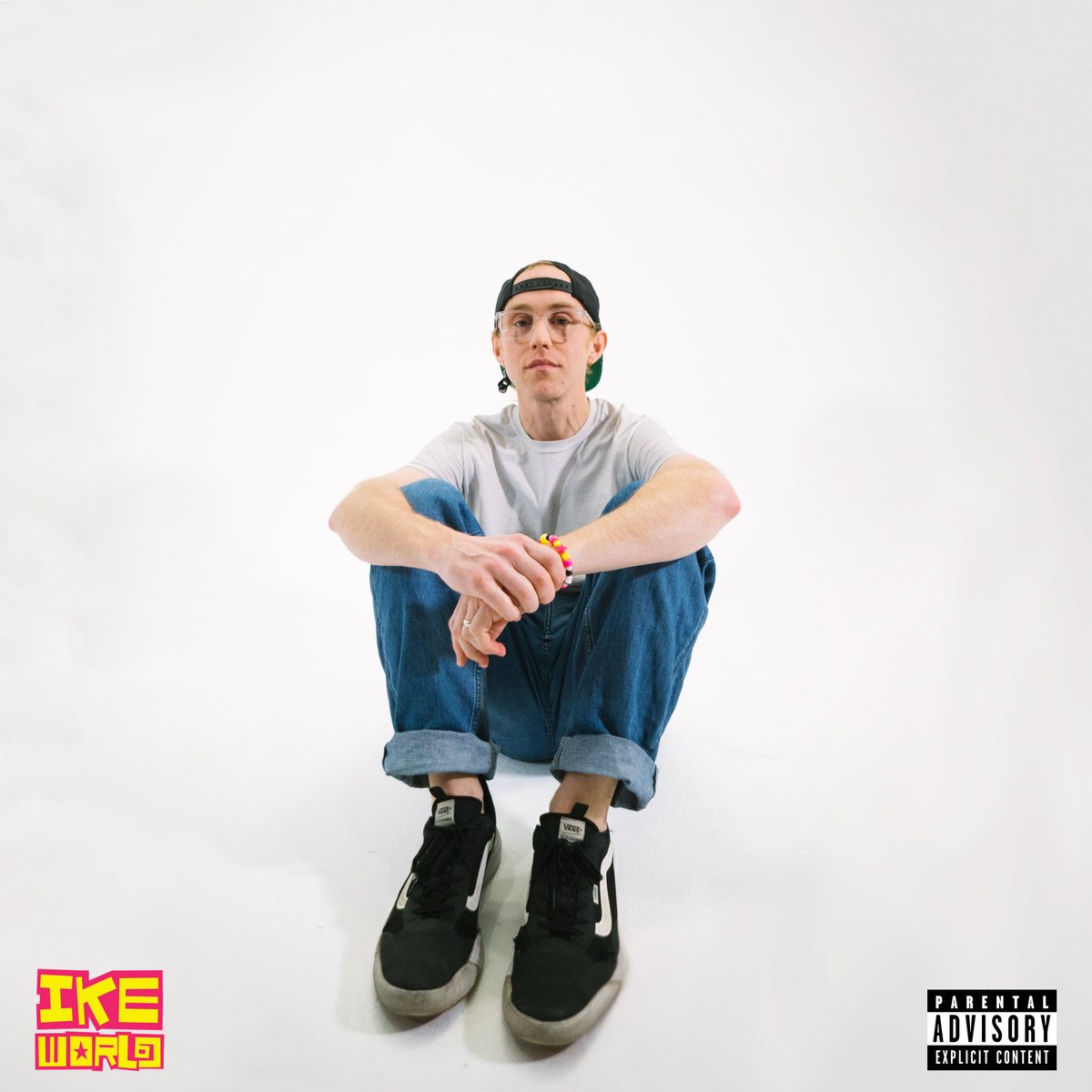 Album art for Ike World by Eichlers. Ike is sitting with knees pulled up to his chest with his arms rest on them.
