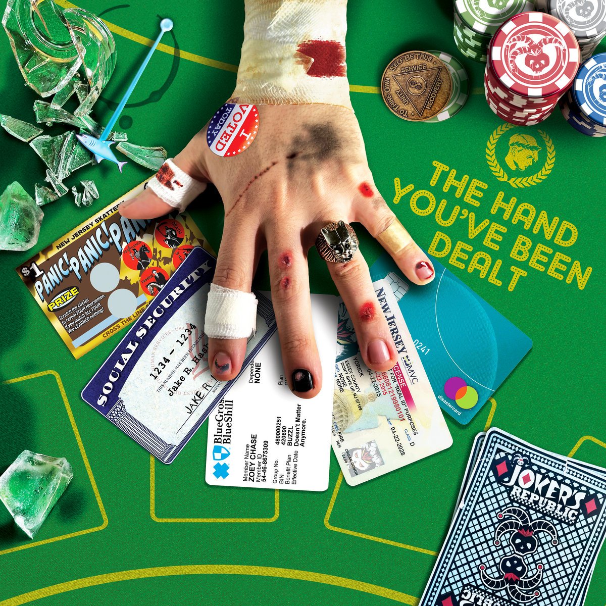 This id the album art for The Hand You’ve been dealt by Joker’s Republic. A hand the looks beat up lays on a poker table under in its various cards associated with modern life. ID, credit card Social Security card and Health insurance card.