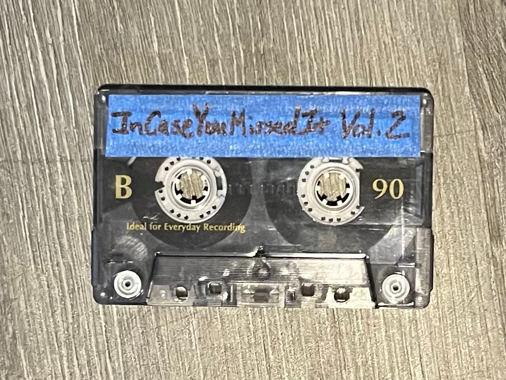 A cassette tape sets alone on the ground its label reads— In Case You Missed It Vol. 2